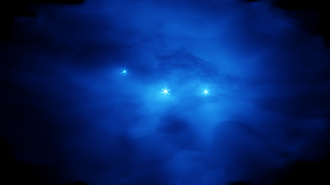 The light of three stars shines through a blue nebula